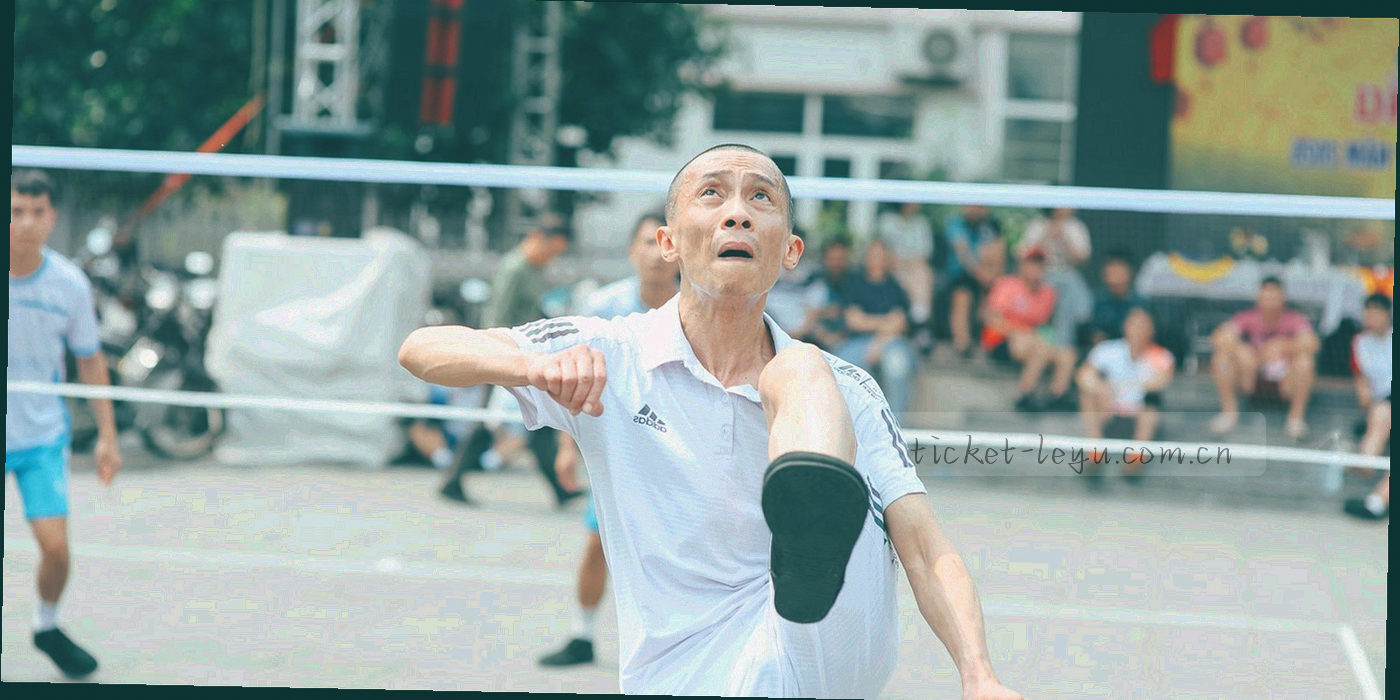 从看台后方拍摄的观众与球场，人物为背影与剪影，强调看台空间感